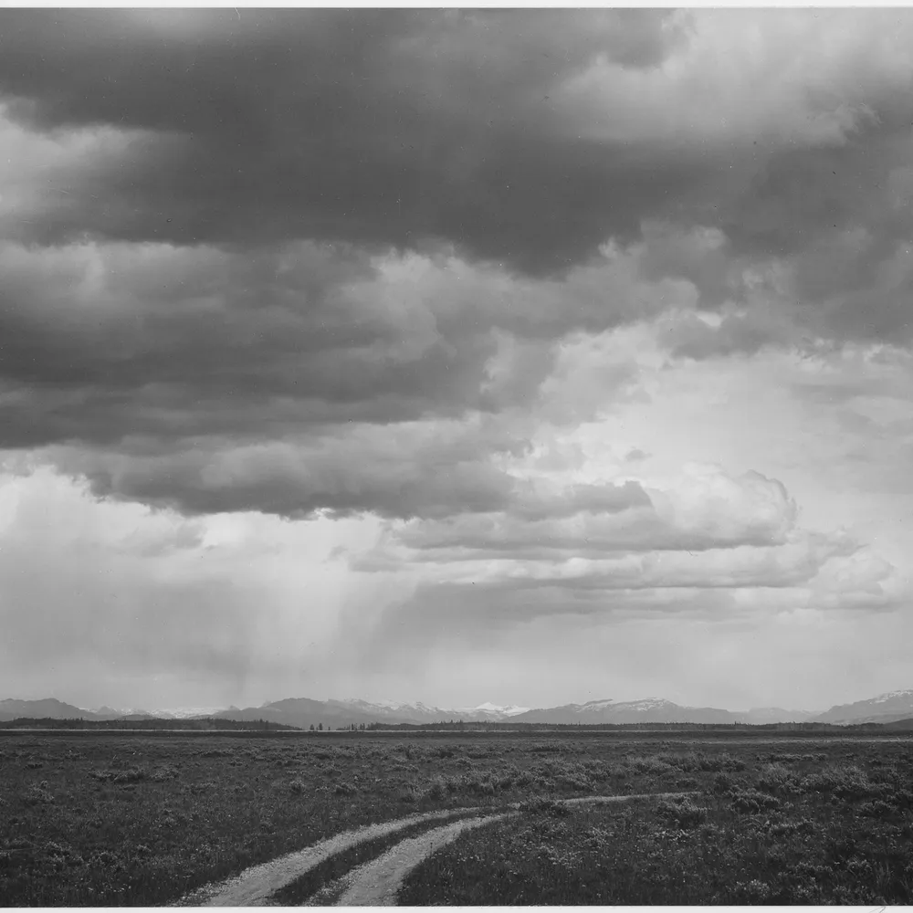 Ansel Adams، "Roadway, low horizon, mountains, clouded sky, Near (Grand) Teton National Park" (1933-1942). أرشيف الوطني الأمريكي (NARA 519911)